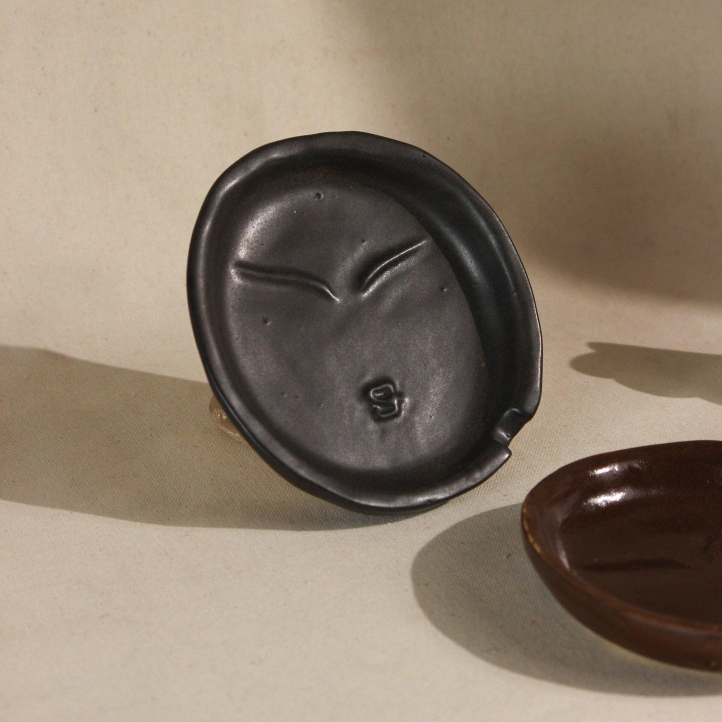 The Sage Face Ceramic Ash Tray in Black and Brown colour